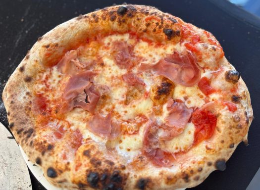 Eine frisch gebackene Pizza mit schmelzendem Käse und knusprigem Rand.